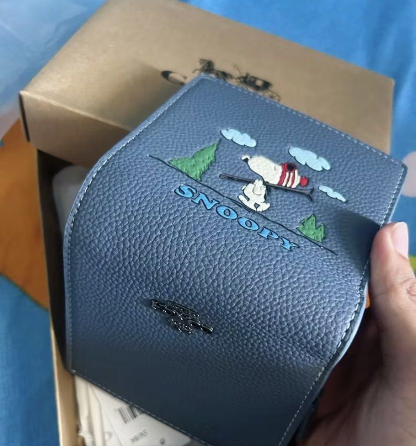Coach x Peanuts Snoopy Bifold Wallet (Category: Wallets & Card holders) located in Makati City. Submitted by ellope (Listing ID 1460688214, Image 2). Description: blue Coach bifold wallet with Snoopy design. Leather, with zip compartment. Includes original box and dust bag. Perfect for Snoopy lovers!.