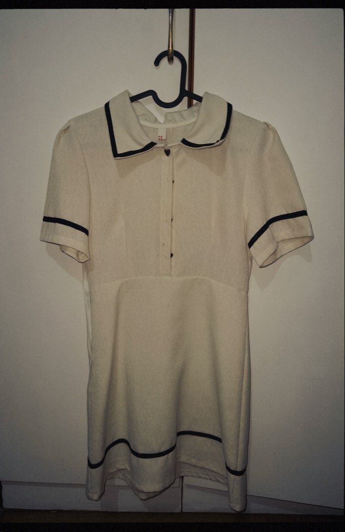 Cream Collared Mini Dress with Black Trim (Category: Dresses) located in Mandaluyong City. Submitted by cuevasmika08421 (Listing ID 1460634261, Image 2). Description: - Cute cream mini dress - Collared neckline with black trim - Short sleeves with black trim - Black trim along the hem - Button-up front with heart-shaped buttons - Textured fabric - Perfect for a retro vibe.