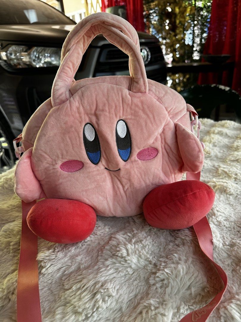 Cute Pink Kirby Plush Round Handbag with Strap (Category: Other Stationery & Craft) located in Digos. Submitted by venusacaro13427 (Listing ID 1460573702, Image 1). Description: - Adorable pink Kirby plush bag - Round and soft design - Features Kirby's iconic face on the front - Includes comfortable handles - Comes with a detachable pink strap printed with 'Kirby' - Ideal for carrying essentials - A must-have for Kirby fans and lovers of cute acc