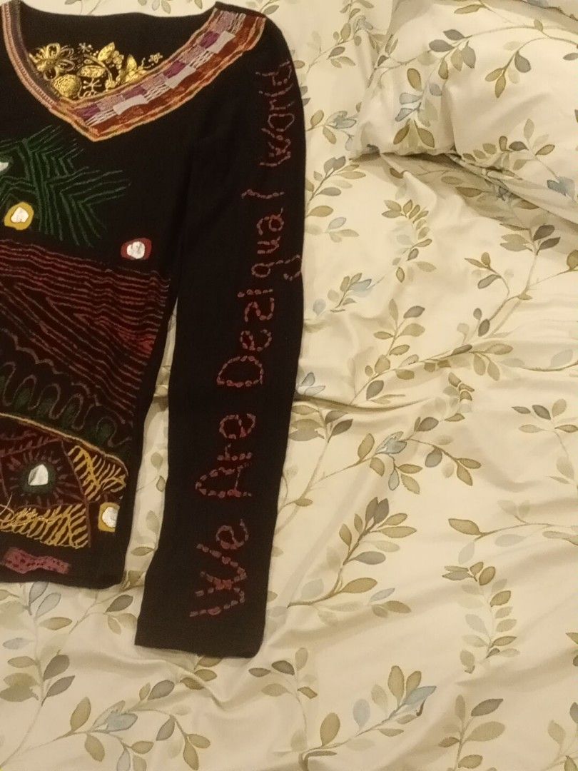 Desigual Black Long Sleeve Top Size M (Category: Longsleeves) located in Manila. Submitted by thriftnmeal (Listing ID 1460653758, Image 2). Description: - Desigual black long-sleeved top - Size M - Vibrant embroidered design with mirrors and gold accents - "We Are Desigual World" text on sleeve - Unique braided detail with buttons on the side - Perfect statement piece.