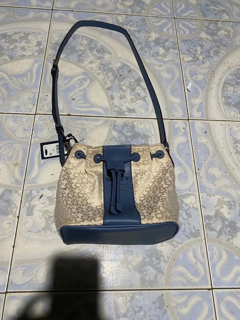DKNY New York Bucket Bag (Category: Luxury Bags & Wallets) located in Talavera. Submitted by jb_alvarez1 (Listing ID 1460611259, Image 1). Description: - Authentic DKNY bucket bag - Features the signature DKNY pattern - Stylish blue leather trim and strap - Secure drawstring closure - Interior zip pocket for essentials - Additional interior snap closure - Includes original tag - Ideal for everyday wear.