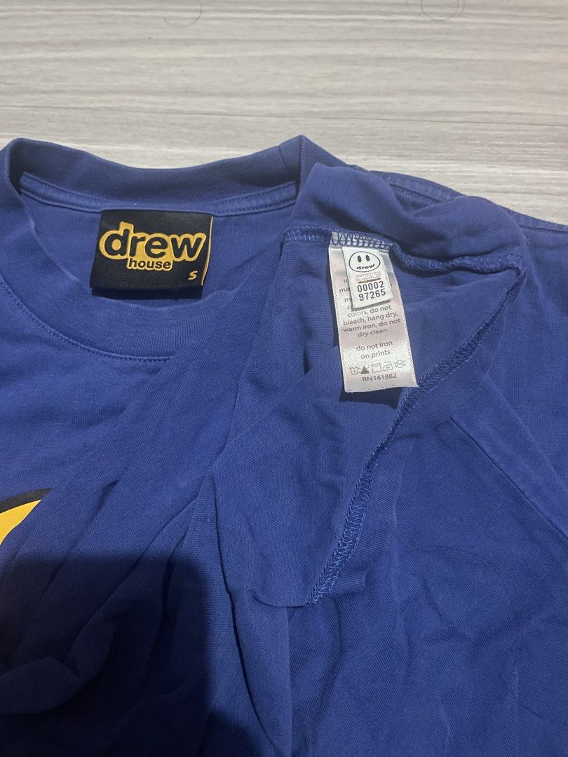 Drew House Tee Royal Blue Size (Category: Tshirts & Polo Shirts ) located in Manila. Submitted by 2002kid (Listing ID 1460653471, Image 3). Description: - Brand: Drew House - Item: Mascot T-Shirt - Color: Royal Blue - Size: S - Design: Classic yellow smiley face logo - Condition: Good, with a small hole near the side hem (visible in the last photo). - Perfect for casual wear and fans of the brand. Size: Small Dimes Width: 21 Length: 27 Issue: sma