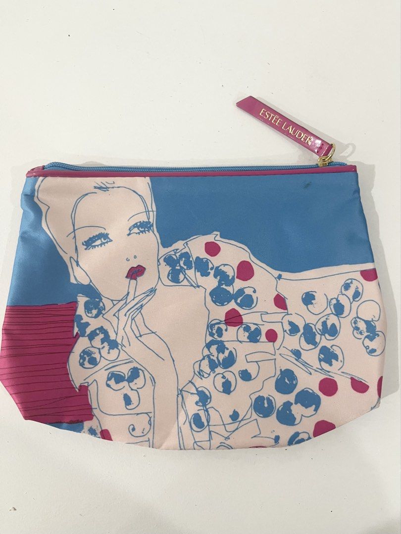 Estee Lauder Cosmetic Bag Pouch (Category: Purses & Pouches) located in Pasig City. Submitted by tinylittlestore (Listing ID 1460714549, Image 1). Description: - Cute Estee Lauder makeup pouch - Fun graphic print featuring a woman and polka dots - Color: Blue and pink exterior - Zipper closure with a pink Estee Lauder pull tab - Bright pink interior - Ideal for organizing makeup or toiletries.
