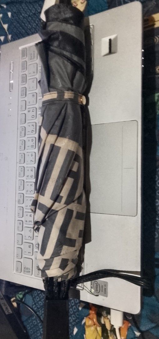 Fendi Monogram Folding Umbrella (Category: Umbrellas) located in Cagayan de Oro. Submitted by brex7 (Listing ID 1460513734, Image 2). Description: - Authentic Fendi monogram umbrella - Classic black and cream colorway - Compact and foldable design - Features Fendi logo on the handle - Includes a convenient wrist strap - Secured with a branded clasp - Ideal for unexpected rainy days.