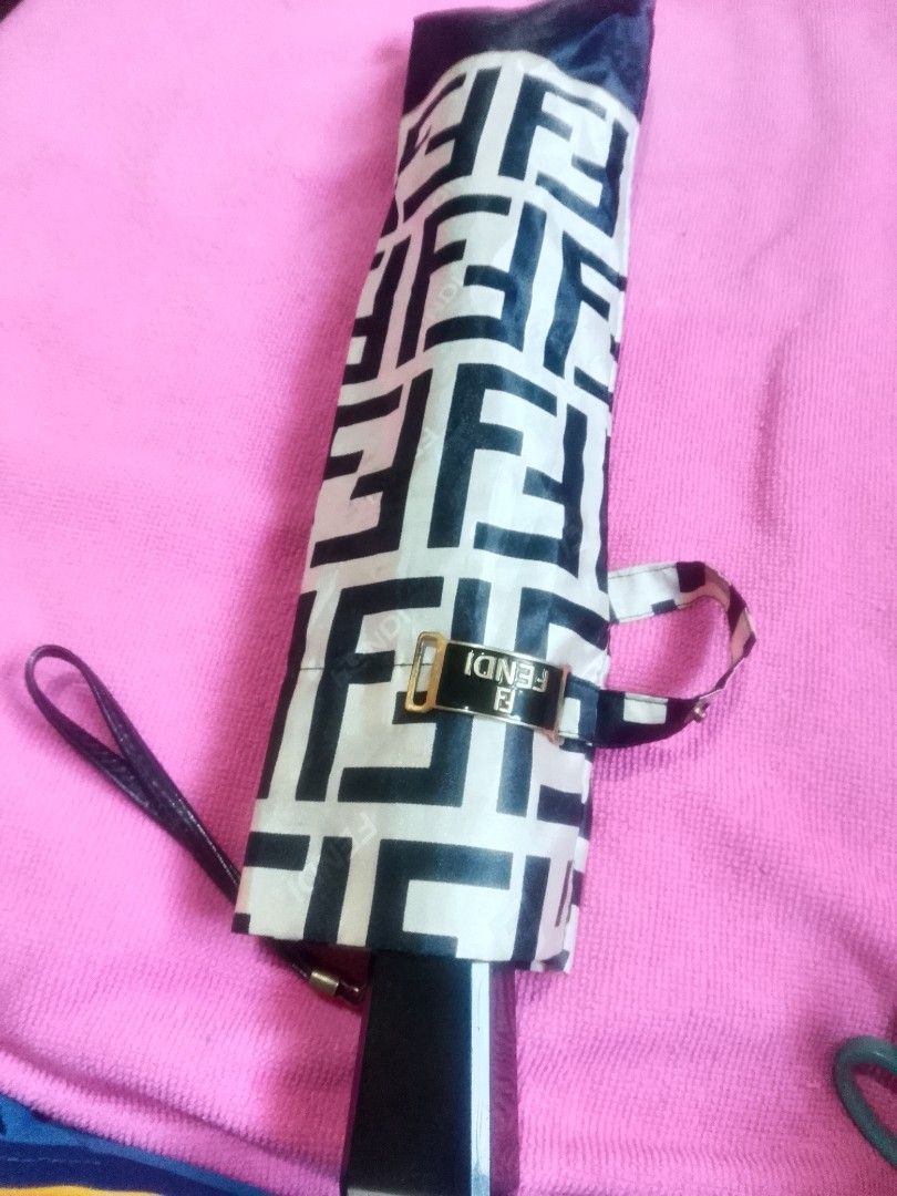 Fendi Monogram Folding Umbrella (Category: Umbrellas) located in Cagayan de Oro. Submitted by brex7 (Listing ID 1460513734, Image 1). Description: - Authentic Fendi monogram umbrella - Classic black and cream colorway - Compact and foldable design - Features Fendi logo on the handle - Includes a convenient wrist strap - Secured with a branded clasp - Ideal for unexpected rainy days.