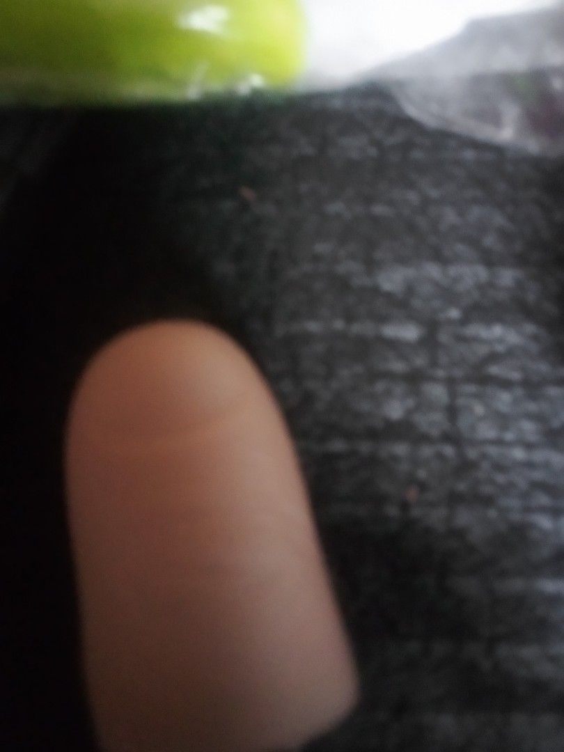 Finger toy light (Category: Tshirts & Polo Shirts ) located in Paranaque City. Submitted by dimaguilaa94969 (Listing ID 1460658104, Image 1). Description: - Realistic finger prop - Light skin tone - Attached to a hand - Dark, textured background for contrast - Blurry green object in background.