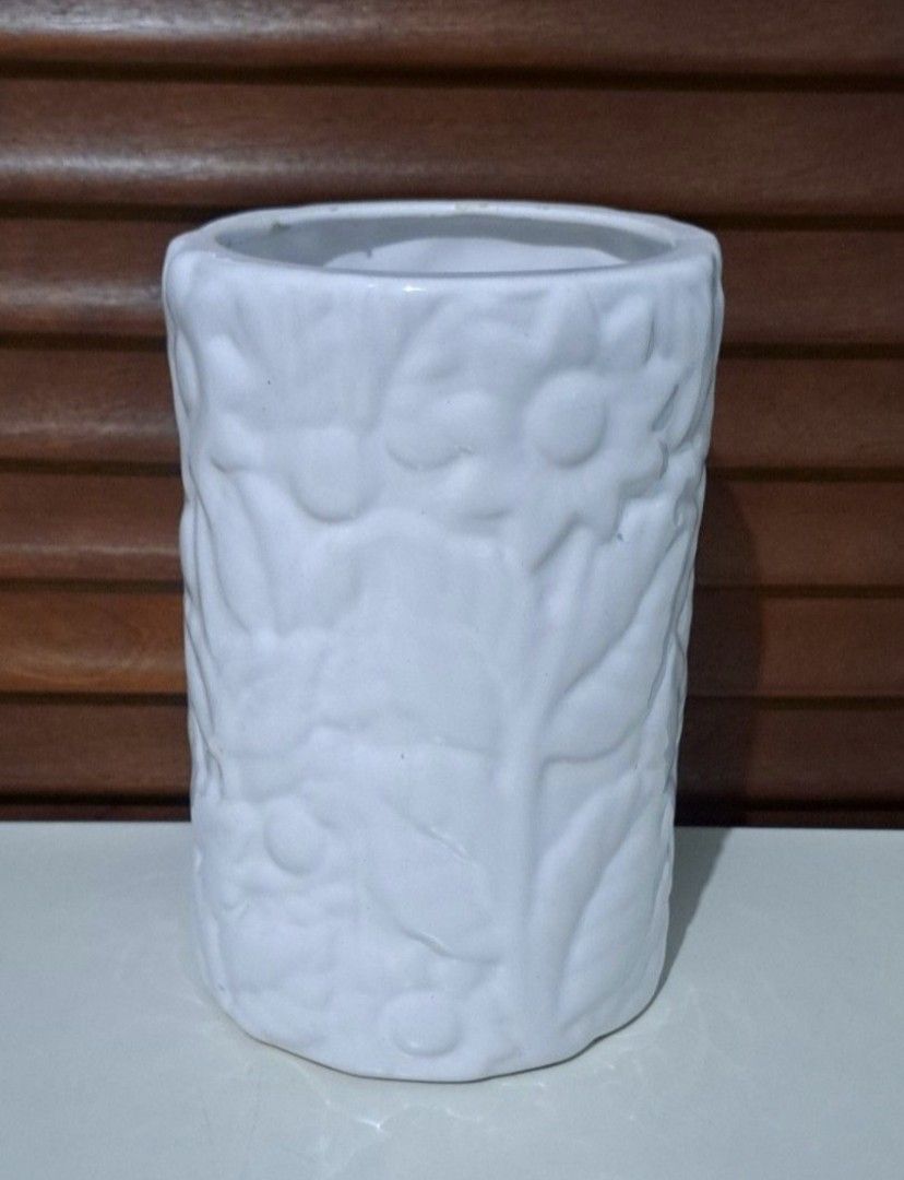 🌸 Flower Embossed Ceramic Vase (Category: Vases & Decorative Bowls) located in Taguig. Submitted by authprelovedonlineshop1 (Listing ID 1460578977, Image 1). Description: ### 🌸 Flower Embossed Ceramic Vase Beautiful **white ceramic vase** with an elegant floral design. 🤍 - Embossed **flower and leaf details** - Cylindrical shape with a textured surface - Wide opening - Oval-shaped base - Approximately **20 cm in height** - Approximately **10 c