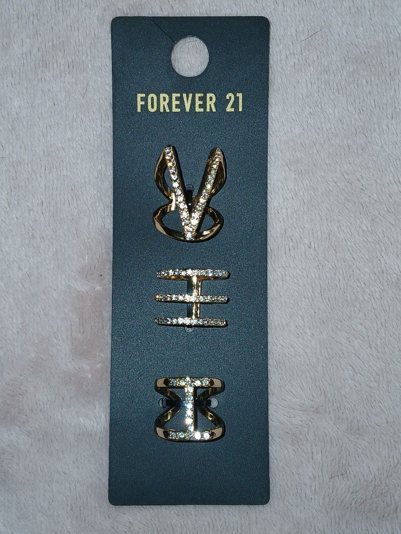 Forever 21 Gold/Clear Rhinestone Ring Set Size 7 (Category: Rings) located in Paranaque City. Submitted by thepennydreadful (Listing ID 1460561735, Image 1). Description: - Set of 3 rings from Forever 21 - Gold tone with sparkling clear rhinestones - Designs include: V-shaped, multi-band, and bow - Comes on original backing card - Original retail price: $9.90.