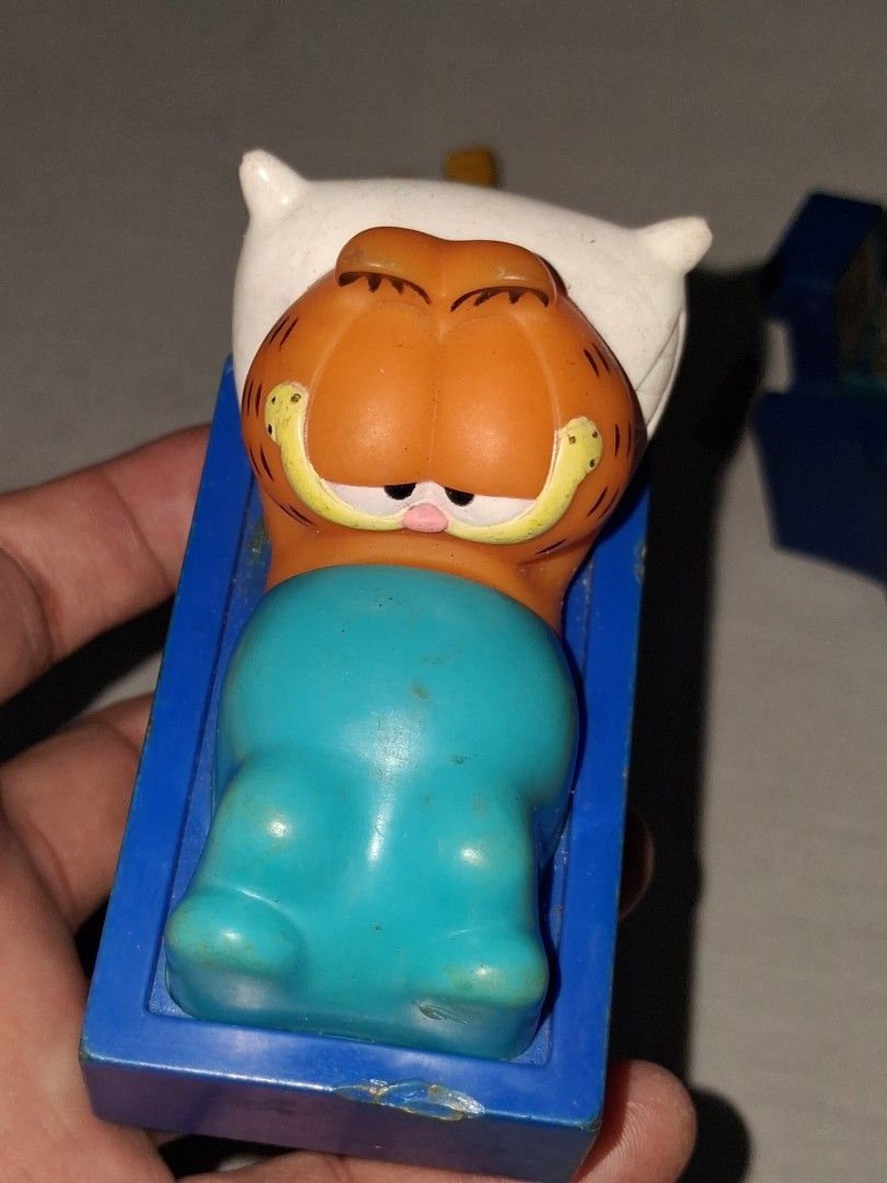 Garfield Sleeping in Bed Toy Figure (Category: Designer & Blind Box Toys) located in Manila. Submitted by marcas022798212 (Listing ID 1460622955, Image 2). Description: - Adorable Garfield toy figure - Depicts Garfield sleeping peacefully in his bed - Made of durable plastic - Perfect for Garfield fans and collectors.