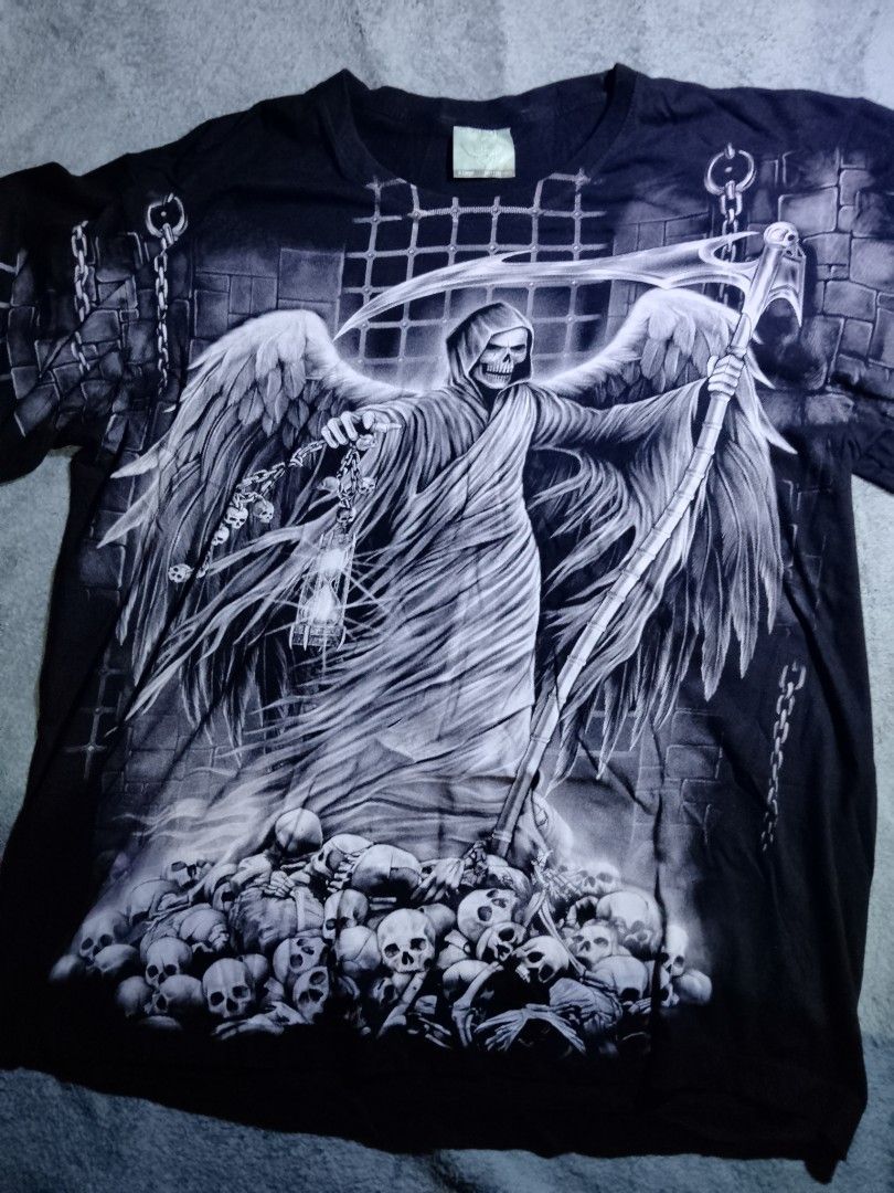 Grim Reaper Skulls T-Shirt (Category: Tshirts & Polo Shirts ) located in La Trinidad. Submitted by stale_cltv (Listing ID 1460658403, Image 1). Description: - Black t-shirt - Large grim reaper graphic on the front - Features wings, scythe, and a pile of skulls - Full front print - Ideal for gothic or dark art enthusiasts.