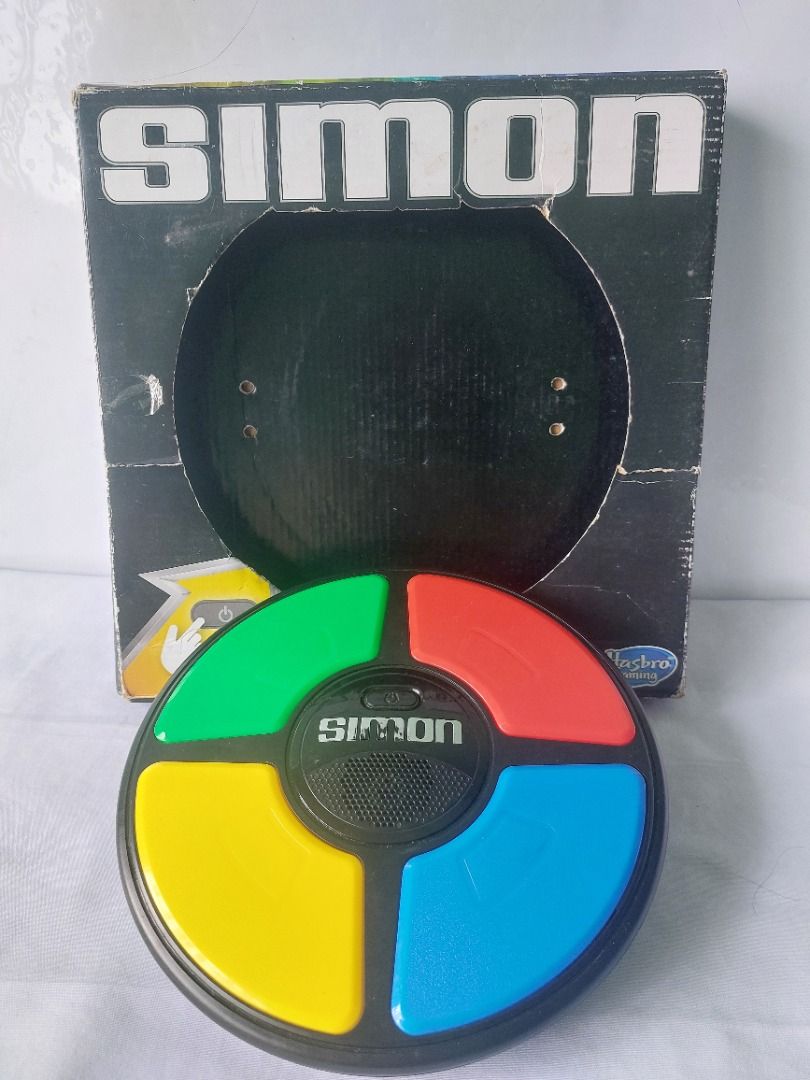 Hasbro Simon Handheld Electronic Memory Game With Lights and Sounds (Category: Educational & Learning Toys) located in Paranaque City. Submitted by ca.firstonlinebiz (Listing ID 1460687048, Image 1). Description: Preloved Classic Simon memory game by Hasbro - Features flashing lights and sounds to test your memory - Includes four colored buttons: red, blue, yellow, and green - Original box is included (shows some wear) - Fun retro electronic game