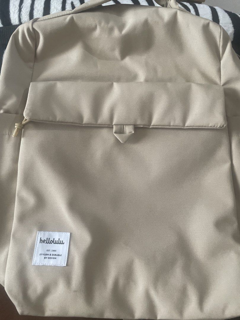 hellolulu Beige Backpack (Category: Backpacks) located in Pasay City. Submitted by tropak_mo (Listing ID 1460565933, Image 1). Description: - Beige hellolulu backpack - Front pocket with magnetic closure - Multiple interior compartments, including a padded laptop sleeve - Side pockets for water bottles - Adjustable straps for comfort - Ideal for daily use or travel.