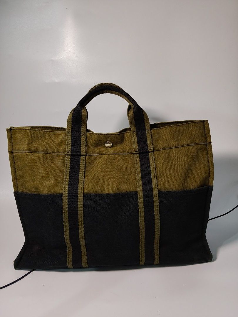 Hermis Canvas Fourre TOUT (Category: Briefcases) located in Valencia. Submitted by coolwolf_27a64f (Listing ID 1460578261, Image 2). Description: HERMÈS Vintage Fourre Tout Canvas Tote. A two-tone Fourre Tout in olive khaki and black cotton canvas - Hermès' take on the practical day tote, born in the late 1990s and still one of the most quietly recognizable pieces from the Paris house. Sturdy woven panels, contrast top section and the signature f