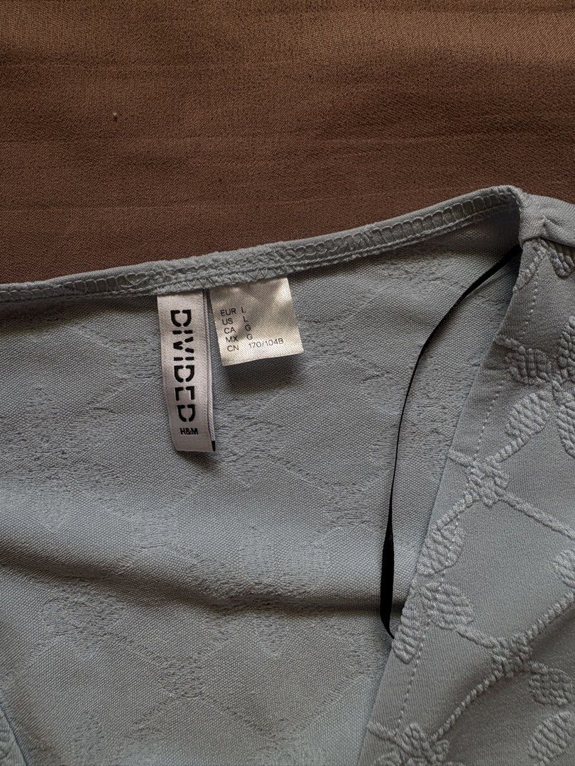 H&M Divided Light Blue Textured Tie Front Top (Category: Sleeveless) located in Marikina City. Submitted by momdeclutterz (Listing ID 1460653505, Image 2). Description: H&M Divided Size L Light blue Can pass as new Used once only during our Team Christmas Party Orig price: ₱799 RFS: Decluttering.