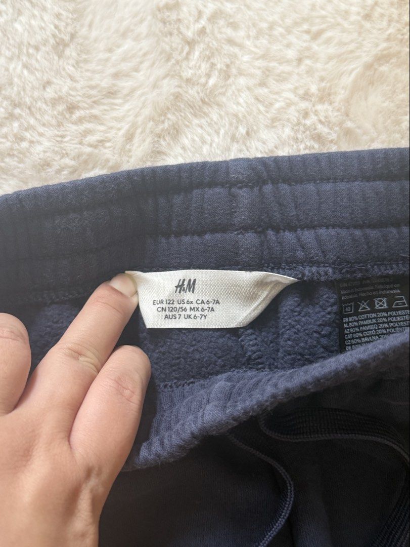 H&M Kids Navy Blue Joggers (Category: Babies & Kids Fashion) located in Lapu Lapu. Submitted by prelovedbymariey (Listing ID 1460536124, Image 2). Description: - Navy blue joggers from H&M - Size EU122 - Elastic waistband with drawstring - Cuffed ankles - Soft fleece lining inside for extra warmth - Ideal for everyday wear and lounging - Versatile: pairs easily with t-shirts and hoodies.