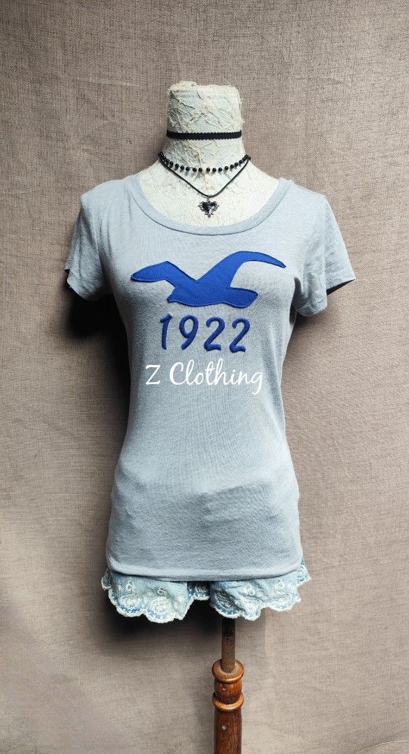 Hollister Top (Category: Shirts) located in Davao. Submitted by z.clothing (Listing ID 1460646065, Image 1). Description: - Light blue t-shirt - Features a blue bird logo - Short sleeves and crew neck - Comfortable and casual design - Ideal for everyday wear.
