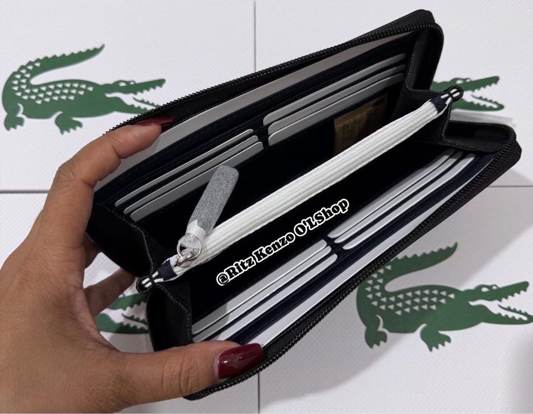 Lacoste Noir L Zip Wallet Polyvinyl Chloride (Category: Wallets & Card Holders) located in Antipolo. Submitted by ritzkenzo_olshop06 (Listing ID 1460538799, Image 3). Description: - Authentic Lacoste wallet in black - Model NF4776OV - Secure zip-around closure - Ample card slots and compartments for organization - Durable polyvinyl chloride (PVC) material - Comes with original tag.