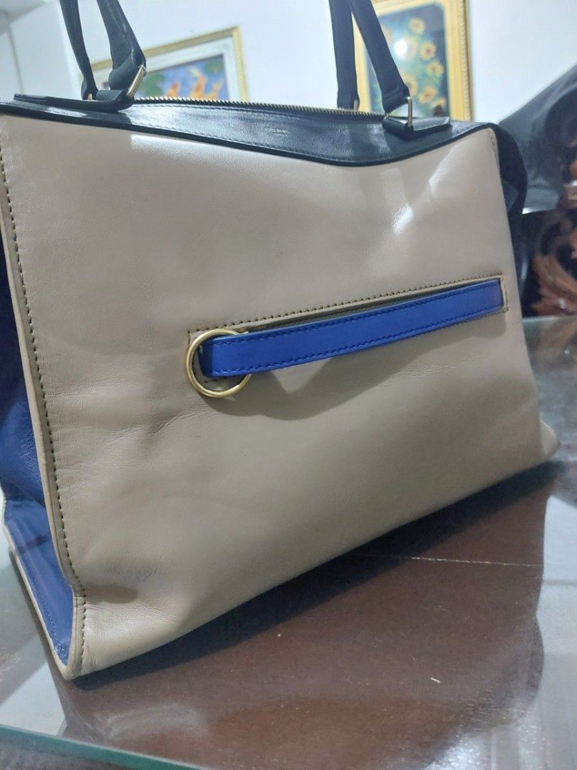 Leather Bag Tricolor (Category: Tote Bags) located in Las Pinas. Submitted by jmproperties (Listing ID 1460712680, Image 2). Description: - Classic beige tote bag - Black leather trim - Two top handles - Blue interior - Four gold-toned metal feet on the bottom - Spacious interior for essentials - Ideal for everyday use.