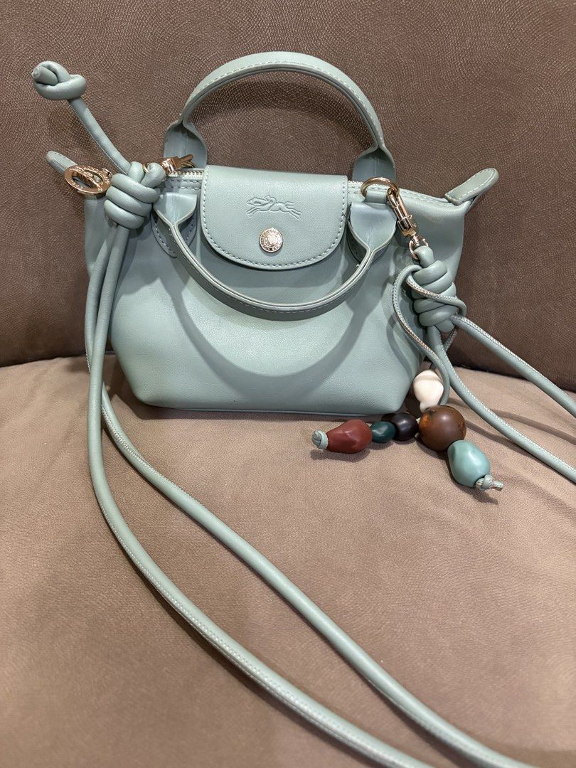Longchamp Le Pliage Cuir Mini Top Handle Bag (Category: Luxury Bags & Wallets) located in Muntinlupa City. Submitted by xiannahailey (Listing ID 1460579215, Image 1). Description: - Light blue Longchamp mini top handle bag - Genuine leather material - Detachable shoulder strap included - Main zippered compartment with interior pockets - Adorable beaded charms - Versatile for everyday or special events.