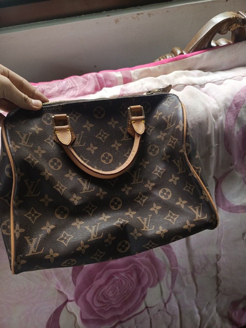 Louis Vuitton Monogram Speedy handbag (Category: Shoulder Bags) located in Manila. Submitted by lucky_106096 (Listing ID 1460599427, Image 1). Description: Louis Vuitton Monogram Speedy handbag features the iconic dark brown Monogram canvas with the classic LV logos and flower symbols. It has light-colored Vachetta leather accents on the handles, piping, and tabs, which naturally darken over time to a deeper honey color.