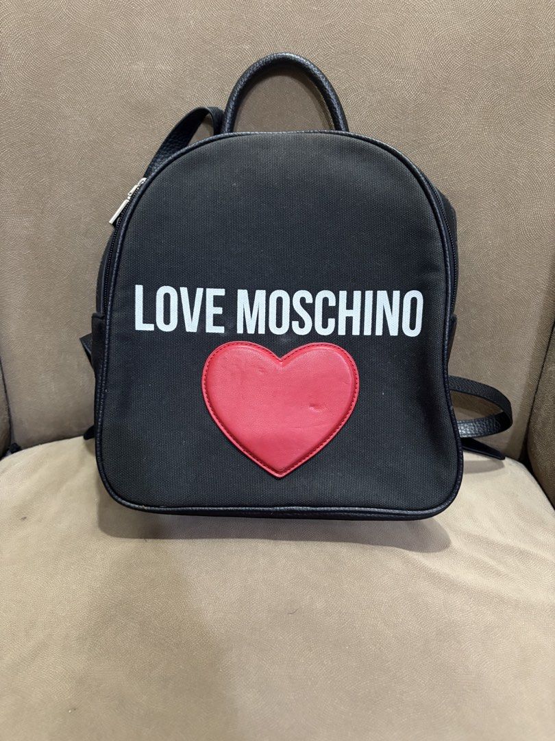 LOVE MOSCHINO Black Canvas Heart Backpack (Category: Backpacks) located in Muntinlupa City. Submitted by xiannahailey (Listing ID 1460577933, Image 1). Description: - Brand: LOVE MOSCHINO - Color: Black - Material: Canvas - Design: Iconic red heart detail on the front - Features: Adjustable straps, interior pocket - Ideal for: Everyday use, stylish accessory.
