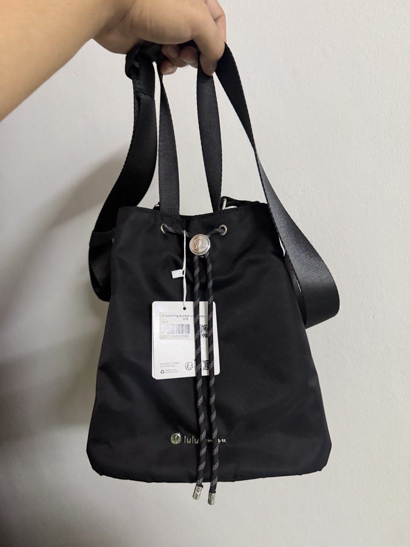 Lululemon Drawstring Bucket Bag 5L (Category: Cross-body Bags) located in Quezon City. Submitted by hoelygrailmnl (Listing ID 1460569882, Image 1). Description: - Black Lululemon drawstring bucket bag - Top handle and crossbody strap for versatile carrying - Convenient zippered side pocket - Ideal for gym sessions or everyday errands - Clean and minimalist design.