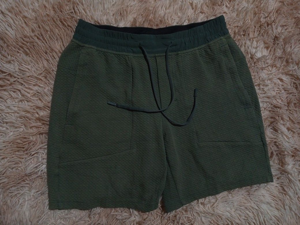 Lululemon Textured Shorts Green (Category: Shorts) located in Boston. Submitted by johnpaulvi30029 (Listing ID 1460649667, Image 2). Description: - Lululemon green textured shorts - Elastic waistband with drawstring - Two side pockets - Lululemon logo on left leg - Made with recycled polyester and elastane - Ideal for workouts or lounging.
