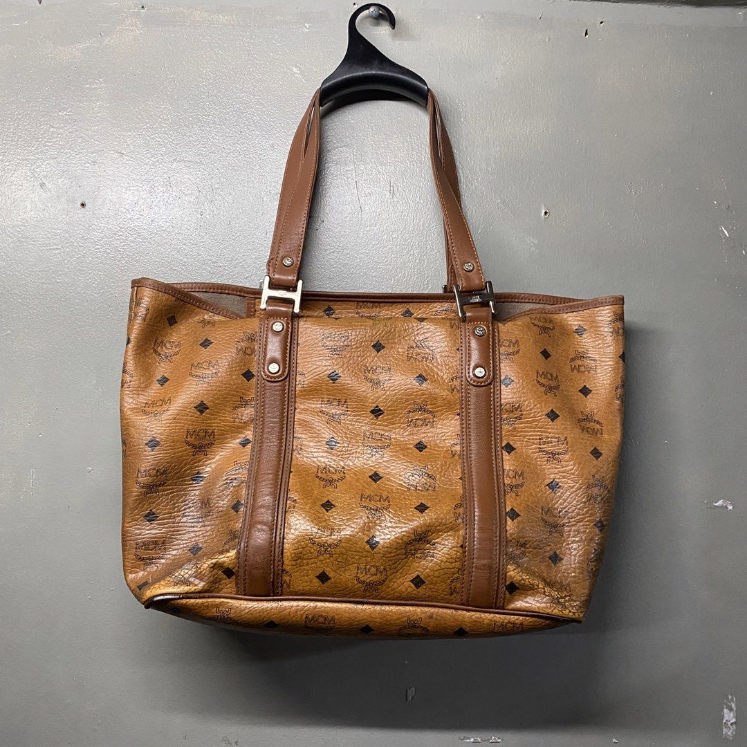 MCM Monogram Tote Bag Brown Leather (Category: Luxury Bags & Wallets) located in Cagayan de Oro. Submitted by sumamestreethub (Listing ID 1460612021, Image 2). Description: - Classic MCM tote bag - All-over brown monogram print - Leather trim and handles - Interior zippered pocket and slip pockets - Some wear on bottom corners and edges - Interior is clean - Great everyday bag.