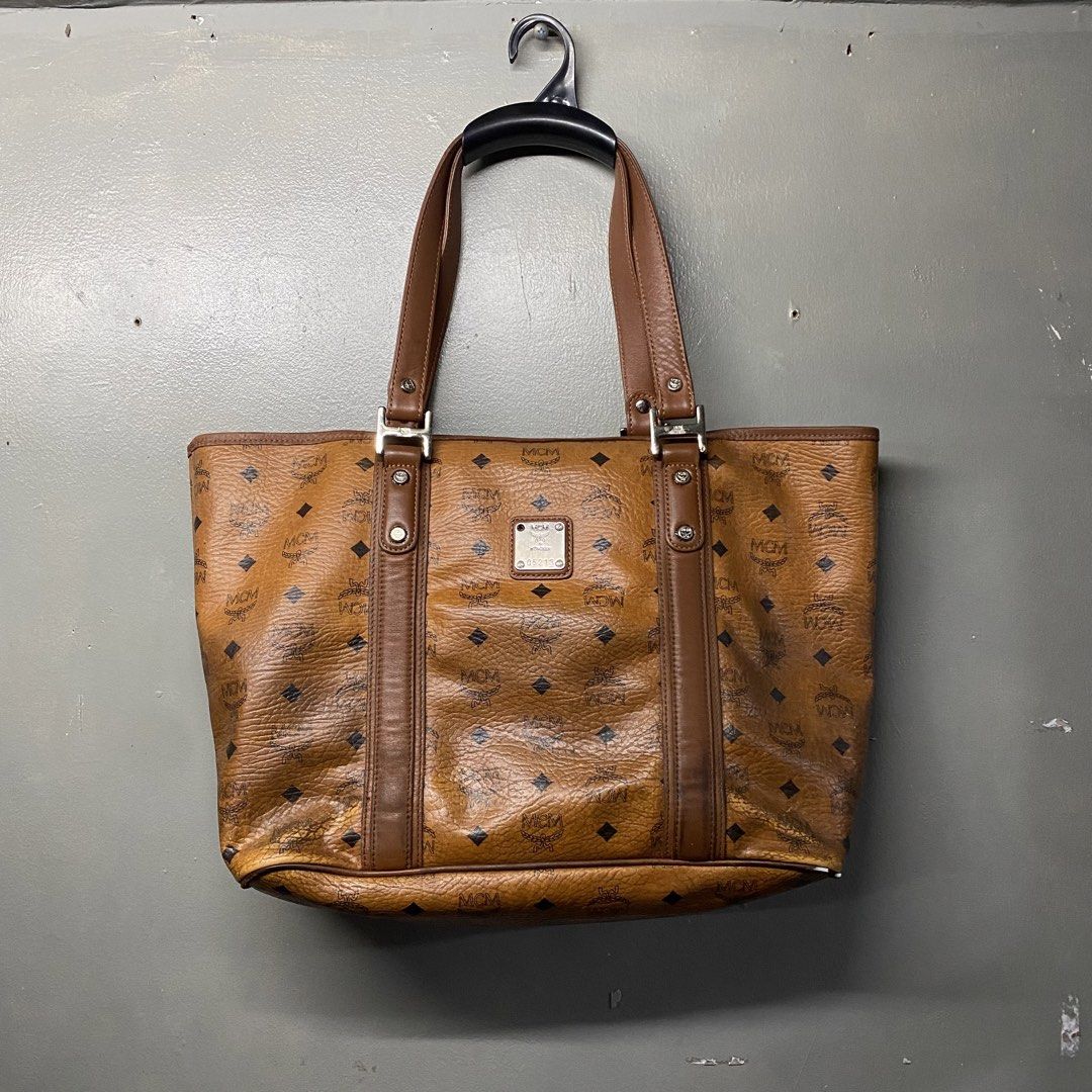 MCM Monogram Tote Bag Brown Leather (Category: Luxury Bags & Wallets) located in Cagayan de Oro. Submitted by sumamestreethub (Listing ID 1460612021, Image 1). Description: - Classic MCM tote bag - All-over brown monogram print - Leather trim and handles - Interior zippered pocket and slip pockets - Some wear on bottom corners and edges - Interior is clean - Great everyday bag.