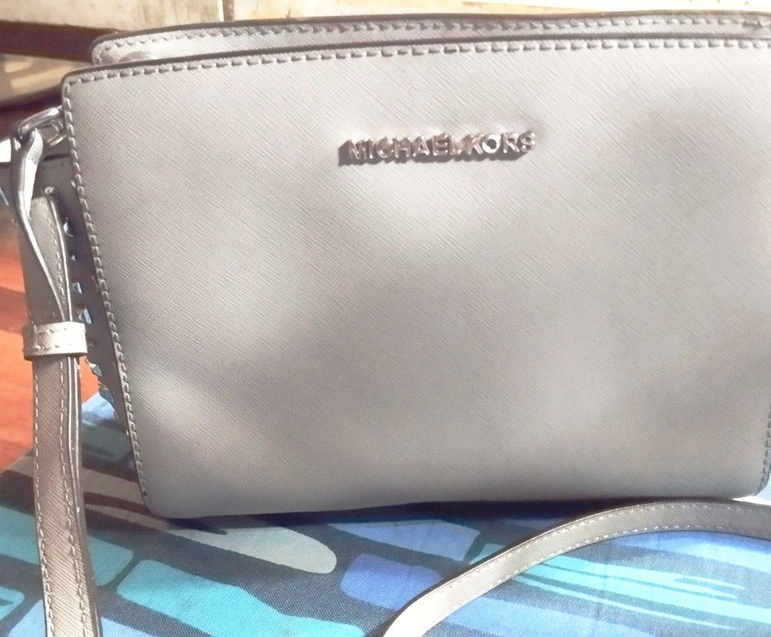 Michael Kors Grey Studded Crossbody Bag (Category: Cross-body Bags) located in Manila. Submitted by lene48 (Listing ID 1460567076, Image 2). Description: - Authentic Grey Michael Kors Crossbody Bag - Stylish silver stud details on the sides - Adjustable strap for comfortable wear - Secure zipper closure - Ideal for everyday use - Interior and exterior are clean - Comes with original dust bag, flaw last pic. .