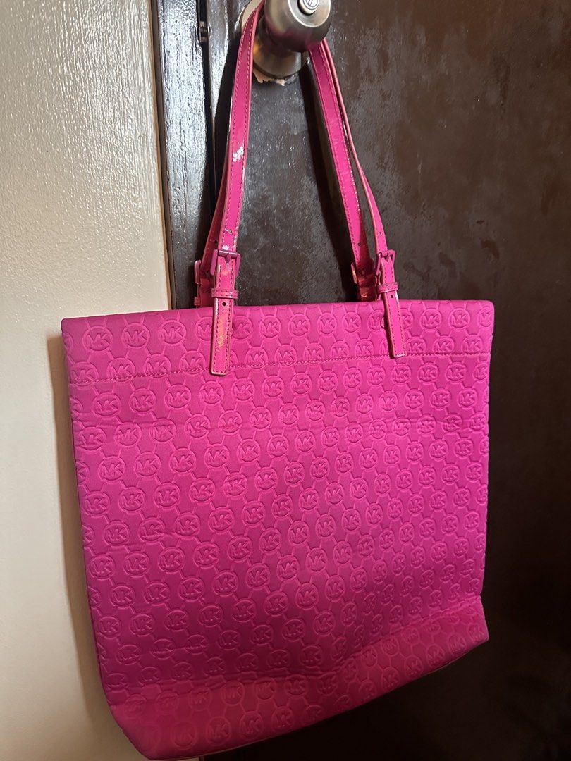 Michael Kors Pink Monogram Tote Bag (Category: Luxury Bags & Wallets) located in Makati City. Submitted by msjlarsen (Listing ID 1460531357, Image 3). Description: - Bright pink Michael Kors tote bag - All-over MK monogram pattern - Patent leather straps and trim - Silver tone hardware with Michael Kors logo plate - Ideal for everyday use or travel - see last photo to see issue of the bag.