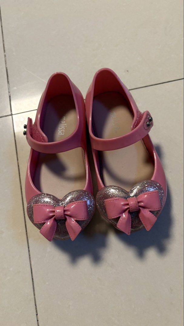 Mini Melissa Pink Glitter Heart US 7 (Category: Babies & Kids Fashion) located in Manila. Submitted by vfjdeclutter (Listing ID 1460536956, Image 1). Description: 13 1/2cm - Adorable pink jelly shoes for kids - Features a sparkly heart with a bow accent - Easy strap closure for a secure fit - Ideal for parties or daily wear - Minor dirt on soles from normal use.