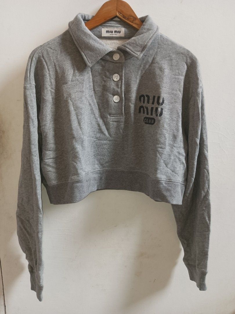 Miu Miu Grey Cropped Collared Sweatshirt (Category: Longsleeves) located in Jolo. Submitted by zah-zah (Listing ID 1460549940, Image 1). Description: - Grey Miu Miu cropped sweatshirt - Collared neckline with button details - Features the Miu Miu Club logo on the front - Made in Italy - Size S - Ideal for a casual look.