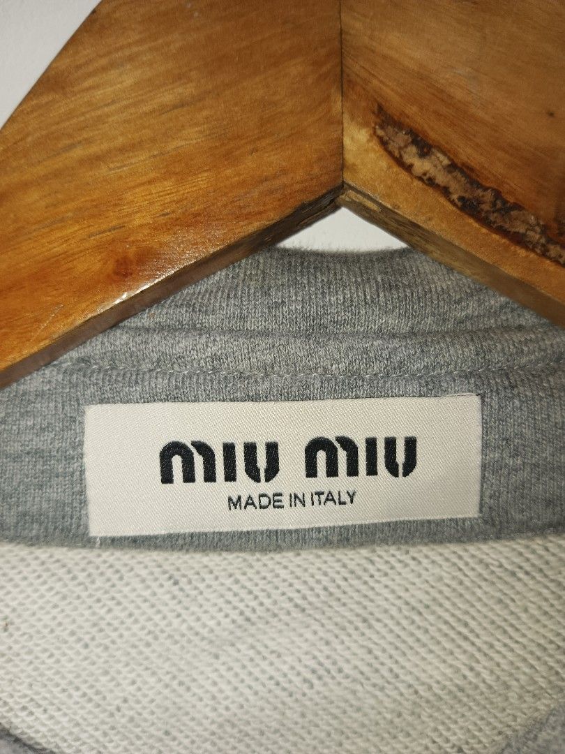 Miu Miu Grey Cropped Collared Sweatshirt (Category: Longsleeves) located in Jolo. Submitted by zah-zah (Listing ID 1460549940, Image 2). Description: - Grey Miu Miu cropped sweatshirt - Collared neckline with button details - Features the Miu Miu Club logo on the front - Made in Italy - Size S - Ideal for a casual look.