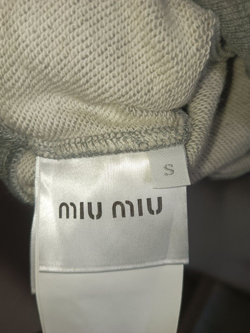 Miu Miu Grey Cropped Collared Sweatshirt (Category: Longsleeves) located in Jolo. Submitted by zah-zah (Listing ID 1460549940, Image 3). Description: - Grey Miu Miu cropped sweatshirt - Collared neckline with button details - Features the Miu Miu Club logo on the front - Made in Italy - Size S - Ideal for a casual look.
