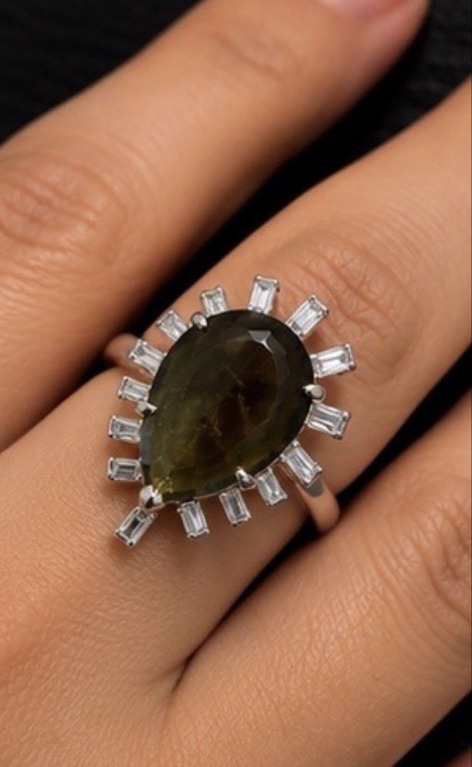 Moldavite (Category: Rings) located in Quezon City. Submitted by chelle2923 (Listing ID 1460664636, Image 2). Description: A breathtaking 3.50 ct Natural Moldavite, expertly fashioned in a stunning Pear-Shaped Step Cut and set in 925 Sterling Silver, accented with brilliant Baguette-Cut Diamonds. 💚✨ 📜 GIT Thailand Certified 💎 Natural Glass (Moldavite) 💚 Yellowish Green 💎 3.50 ct ✨ Pear Shape | Step Cut 🤍 925 Sterling Silver Setting 💎 Bague