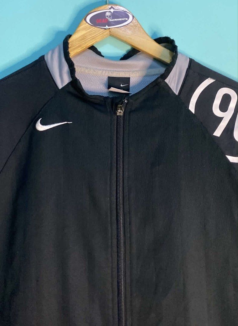 Nike (90) Black Track Jacket (Category: Coats, Jackets and Outerwear) located in Manila. Submitted by deadgarments (Listing ID 1460653027, Image 2). Description: - Black Nike track jacket - Features a '90' graphic on the sleeve - Zip-up front with convenient pockets - Stylish grey collar and sleeve trim - Made in China - Ideal for casual wear or athletic activities.