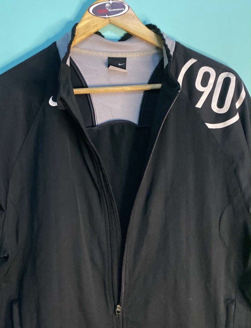Nike (90) Black Track Jacket (Category: Coats, Jackets and Outerwear) located in Manila. Submitted by deadgarments (Listing ID 1460653027, Image 3). Description: - Black Nike track jacket - Features a '90' graphic on the sleeve - Zip-up front with convenient pockets - Stylish grey collar and sleeve trim - Made in China - Ideal for casual wear or athletic activities.