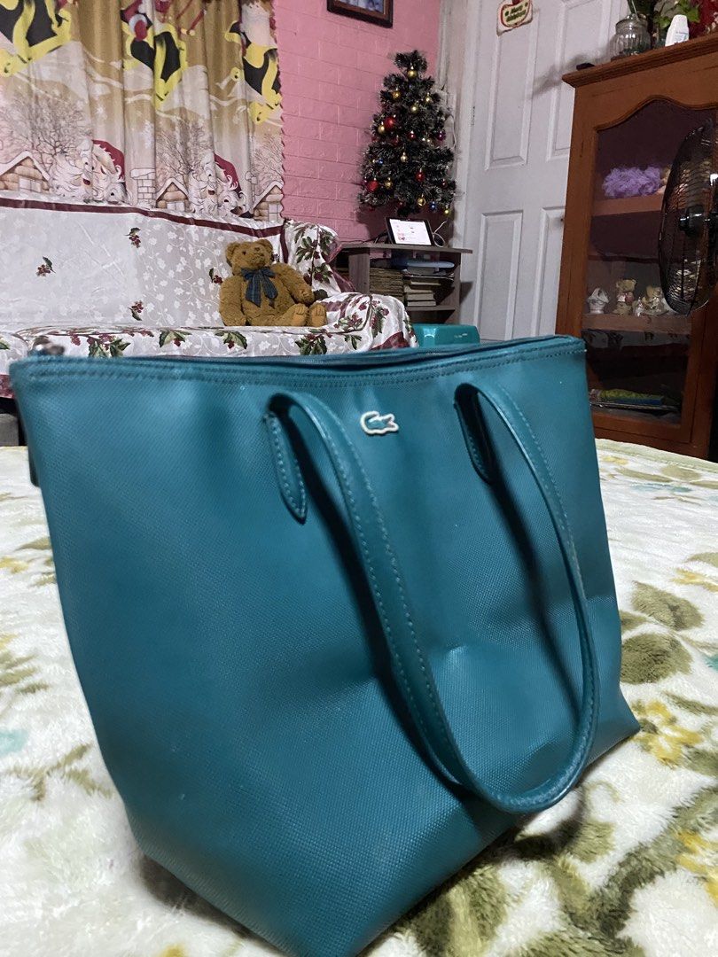 ORIGINAL Lacoste Teal Tote Bag (Category: Tote Bags) located in Tacurong. Submitted by phthriftclothing (Listing ID 1460626012, Image 2). Description: - Teal Lacoste tote bag - Made in Vietnam - Exterior: 100% PVC - Zipper closure for security - Iconic crocodile logo on the front - Small leather tag with 'LACOSTE' embossed - Interior lining is visible - Great size for daily use may dents lang sa ilalim pero hindi halata.