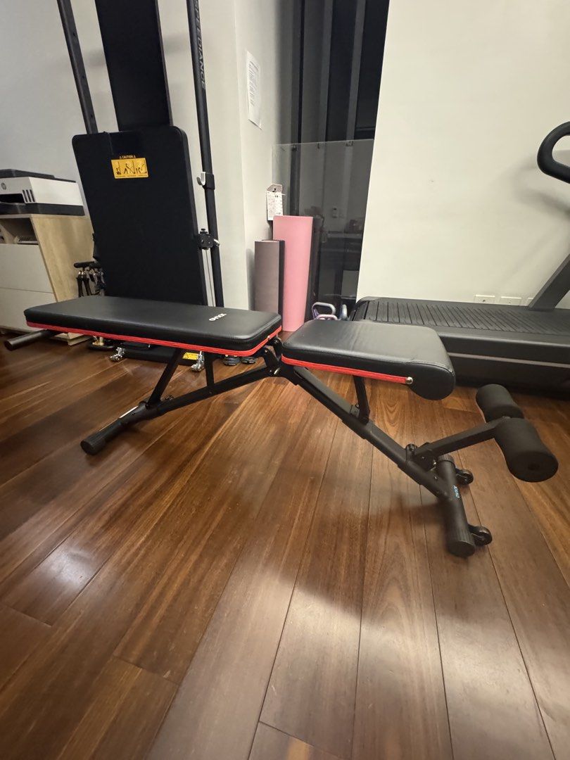 OVIOX Adjustable Weight Training Bench (Category: Weights & Dumbbells) located in Makati City. Submitted by juxyluxy (Listing ID 1460657054, Image 2). Description: - Adjustable weight bench for versatile home workouts - Suitable for sit-ups, weightlifting, and building strength - Comfortable padded backrest and seat - Durable and sturdy metal frame with stylish red accents - Easily adjustable incline for different exercises.