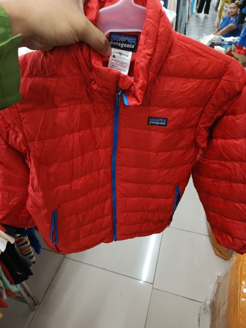 Patagonia Red Down Jacket (Category: Coats, Jackets and Outerwear) located in Cabatuan. Submitted by penthegreat (Listing ID 1460711251, Image 1). Description: - Red Patagonia puffer jacket - Blue zipper and pocket details - Lightweight and packable design - Excellent for staying warm - Ideal for outdoor activities and everyday wear - Please check photos for condition details.