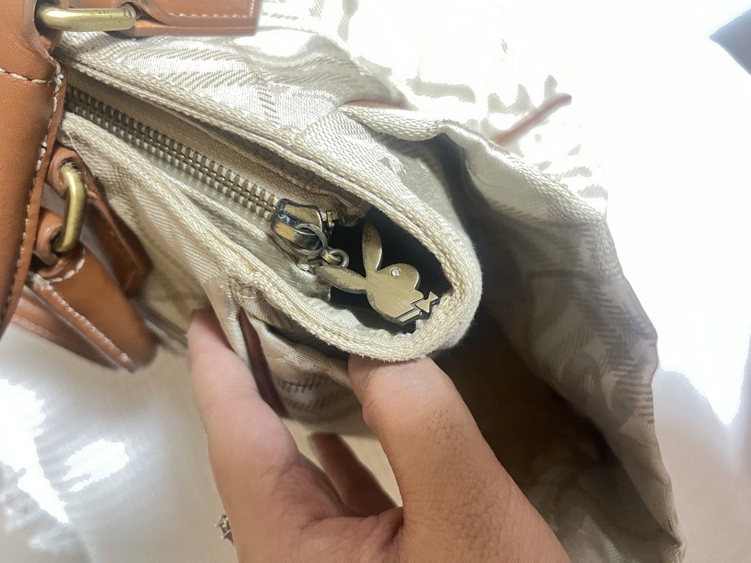 Playboy Monogram Tote Bag (Category: Luxury Bags & Wallets) located in Manila. Submitted by l0vecor3 (Listing ID 1460638858, Image 3). Description: - Classic Playboy tote bag - Beige and brown plaid monogram pattern - Leather trim and handles - Spacious interior - Interior zip pocket - Iconic Playboy bunny zipper pull - Ideal for everyday use.