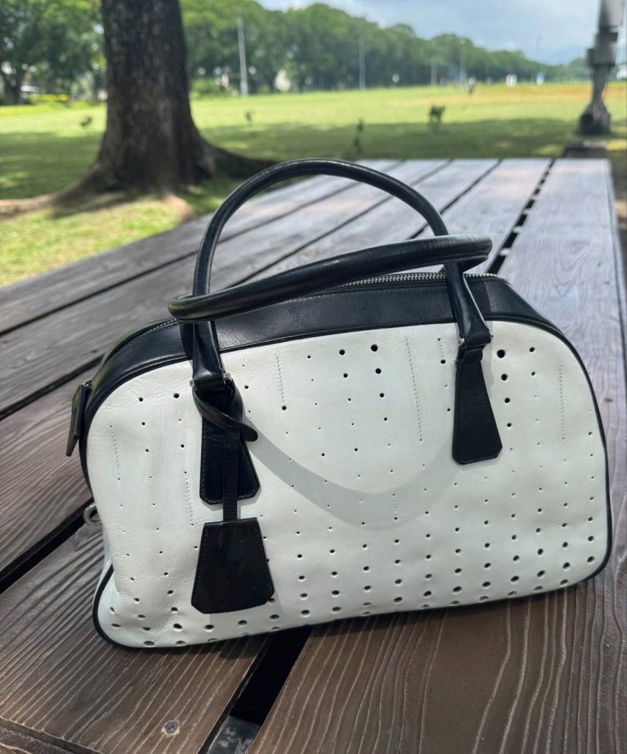 Prada Spring / Summer 2000 Bowler Bag (White Leather) (Category: Luxury Bags & Wallets) located in Angeles City. Submitted by thala.1204.68 (Listing ID 1460530981, Image 1). Description: - Aunthentic Classic Prada Bowler Bag with B101 Revue certificate/ 100% original - Black and white perforated leather - Top handles - Zip closure - Iconic Prada logo hardware - Stylish for any outfit - Great for daily use or special occasions.