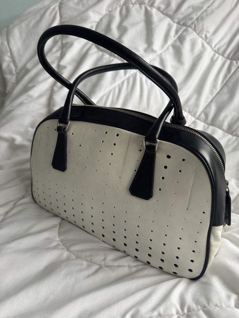 Prada Spring / Summer 2000 Bowler Bag (White Leather) (Category: Luxury Bags & Wallets) located in Angeles City. Submitted by thala.1204.68 (Listing ID 1460530981, Image 3). Description: - Aunthentic Classic Prada Bowler Bag with B101 Revue certificate/ 100% original - Black and white perforated leather - Top handles - Zip closure - Iconic Prada logo hardware - Stylish for any outfit - Great for daily use or special occasions.