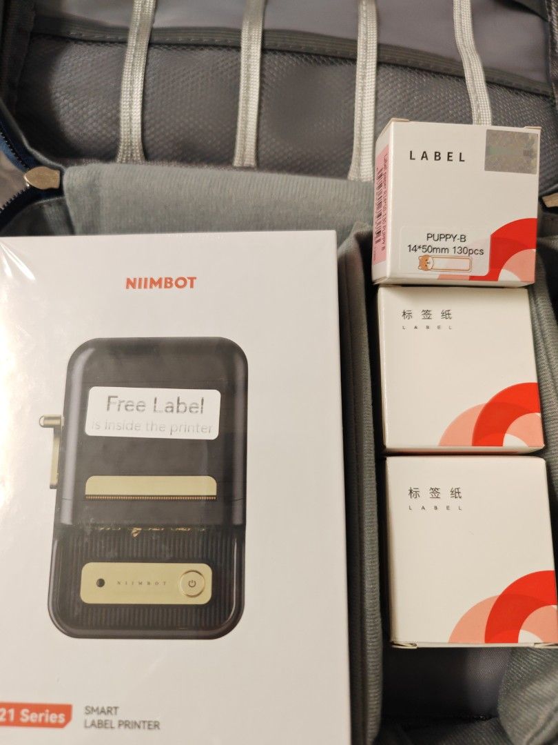 Printer (Category: Printers, Scanners & Copiers) located in Singapore. Submitted by ffeya (Listing ID 1460657692, Image 1). Description: Niimbot B21 series smart label printer. Features: Wireless Bluetooth portable inkless thermal sticker printer for home, office, and small business organization. - Supplies: Includes thermal label rolls (such as the 14x50mm size shown on the right.