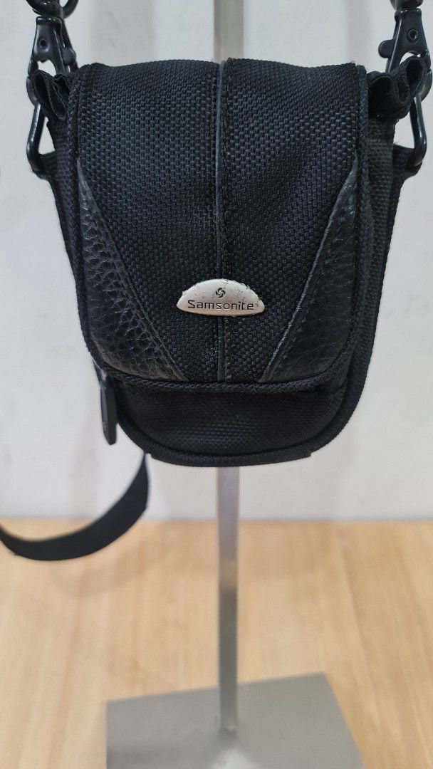 Samsonite Black Camera Bag with Strap (Category: Cross-body Bags) located in Caloocan City. Submitted by royaldragon_d59aba (Listing ID 1460653120, Image 1). Description: - Genuine Samsonite camera bag in black. - Made from durable nylon with stylish faux leather accents. - Compact size, perfect for a small camera and essential accessories. - Features an adjustable shoulder strap for comfortable carrying. - Iconic Samsonite logo clearly visible. 