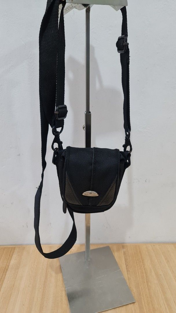 Samsonite Black Camera Bag with Strap (Category: Cross-body Bags) located in Caloocan City. Submitted by royaldragon_d59aba (Listing ID 1460653120, Image 2). Description: - Genuine Samsonite camera bag in black. - Made from durable nylon with stylish faux leather accents. - Compact size, perfect for a small camera and essential accessories. - Features an adjustable shoulder strap for comfortable carrying. - Iconic Samsonite logo clearly visible. 