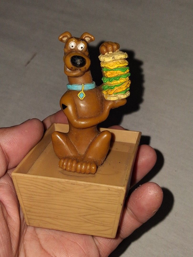 Scooby-Doo toy with wheels and box (Category: Kids Toys) located in Manila. Submitted by marcas022798212 (Listing ID 1460619395, Image 1). Description: - Vintage Scooby-Doo toy - Features wheels on the bottom - Includes a small box - Scooby is depicted holding a stack of sandwiches - Made in China - Ideal for collectors and fans of the Scooby-Doo show.