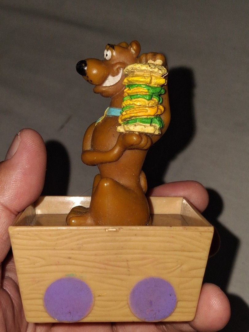 Scooby-Doo toy with wheels and box (Category: Kids Toys) located in Manila. Submitted by marcas022798212 (Listing ID 1460619395, Image 2). Description: - Vintage Scooby-Doo toy - Features wheels on the bottom - Includes a small box - Scooby is depicted holding a stack of sandwiches - Made in China - Ideal for collectors and fans of the Scooby-Doo show.