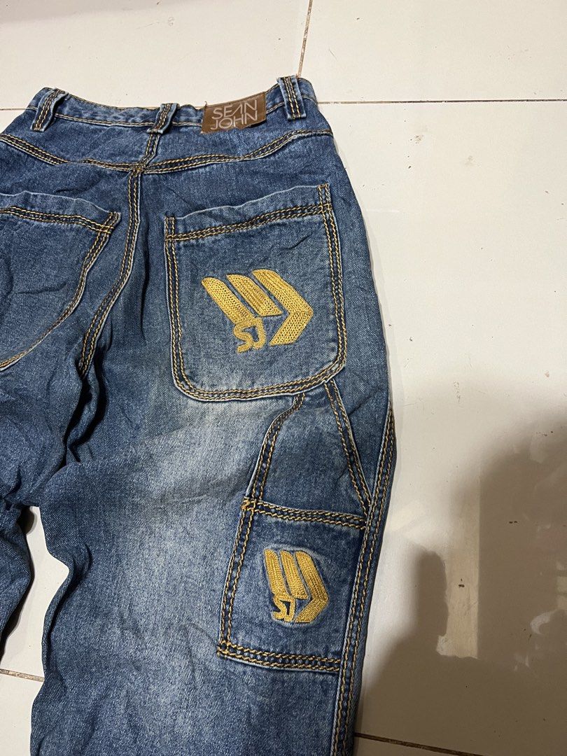 Sean John Denim Jeans Size 28 (Category: Jeans) located in Butuan. Submitted by nikthrift. (Listing ID 1460674241, Image 3). Description: - Sean John denim jeans - Classic blue wash with yellow stitching - Iconic SJ logo embroidered on back pocket - Smaller SJ logo on side cargo pocket - Size: 28 waist - Material: 100% Cotton - Ideal for a streetwear look - size 28 waistline - 39 length - 12.5 leg opening - 9 hem.